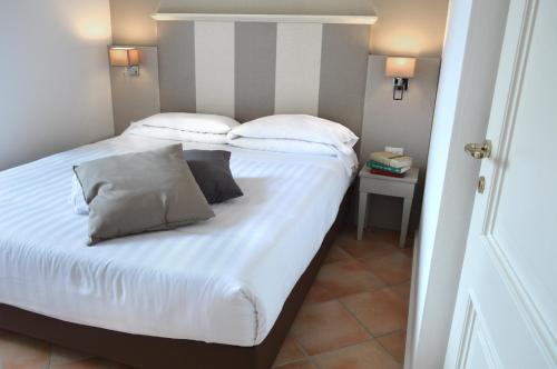 a bedroom with a bed with white sheets and pillows at Hotel Gajeta in Gaeta