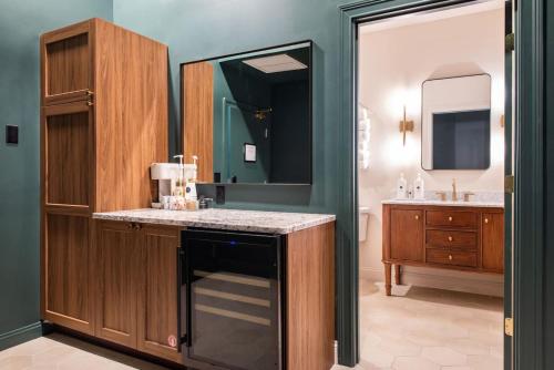 a bathroom with a sink and a vanity with a mirror at Hollyhock Suite 404 in Louisville