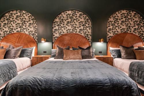 a bedroom with two large beds with wooden headboards at Hollyhock Suite 404 in Louisville