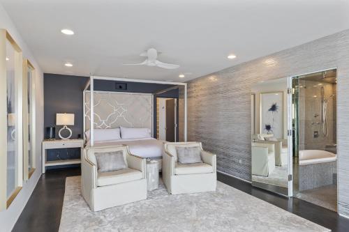 a bedroom with a bed and two chairs and a tub at Encinitas Shores - Beachfront, Ocean View & Patio in Encinitas