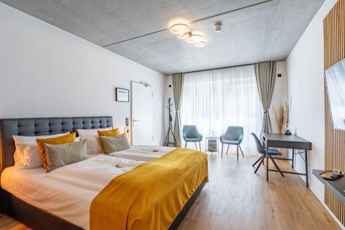 a bedroom with a large bed and a desk at LÜTTES LOFT Boutique Hotel in Eckernförde