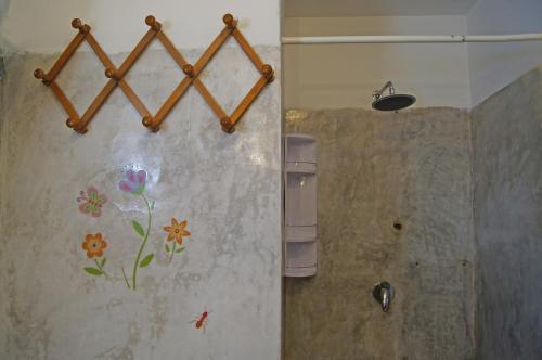 a bathroom with a flower mural on the wall at Villa Alba Appartamenti in Kamma