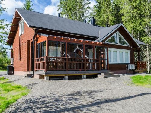 a large wooden house with a large porch at Holiday Home Villa valo by Interhome in Kolinkylä
