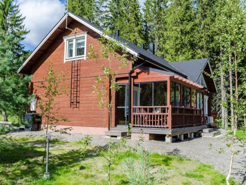 a log cabin in the woods with a porch at Holiday Home Villa valo by Interhome in Kolinkylä