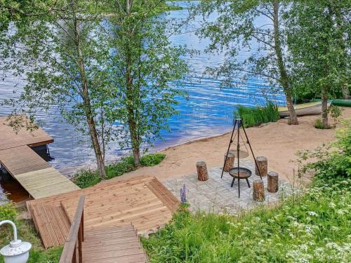 a wooden dock next to a lake with a swing at Holiday Home Salmiranta by Interhome in Jämijärvi