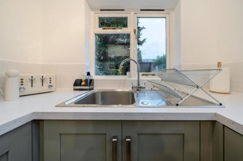 a kitchen with a sink and a window at Spacious 2-Bed House with Garden Office in Oxford