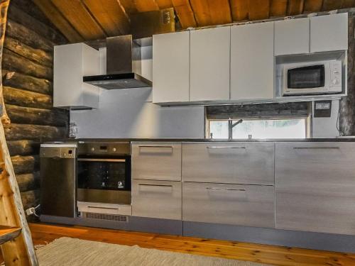 a kitchen with stainless steel appliances and white cabinets at Holiday Home Kelokota by Interhome in Salla
