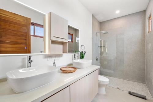 a white bathroom with a sink and a toilet at Panaromic Oceanview Luxury 3BR Private Rooftop in Tamarindo