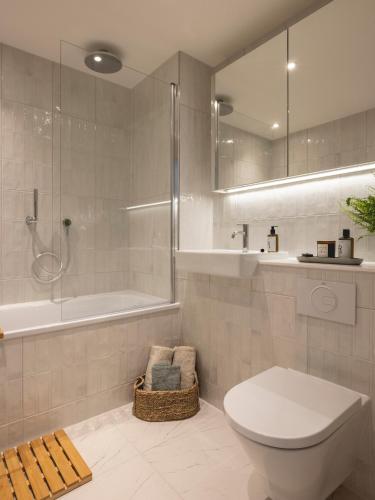 a bathroom with a toilet and a shower and a tub at Charles Hope Cambridge in Cambridge