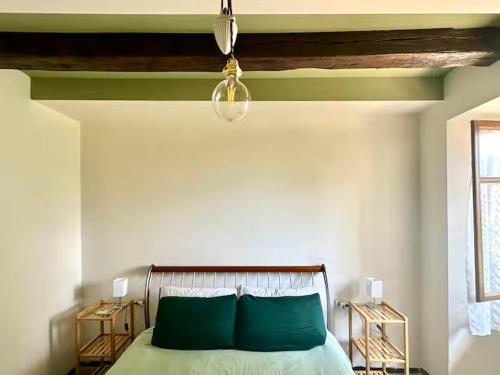 a bedroom with a bed with green pillows and a ceiling at Residenza Renata in Onno
