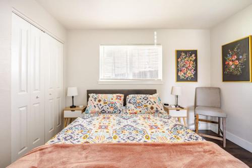 a bedroom with a bed and two chairs and a window at 721 Cozy Mid-Town Hideaway in Reno