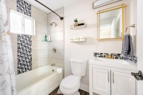 a bathroom with a toilet and a tub and a sink at 721 Cozy Mid-Town Hideaway in Reno