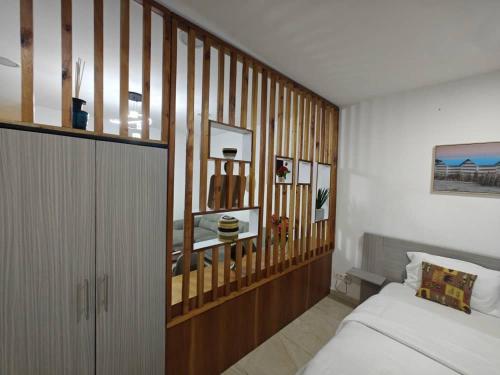 a bedroom with a bed and a wooden wall at Bark luxury apartments Abidjan Attoban 2 in Abidjan