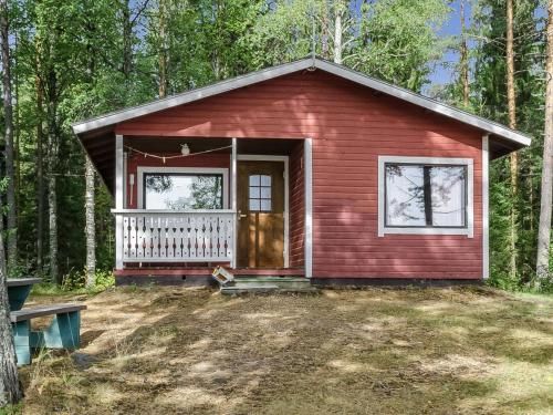 a red tiny house in the middle of the woods at Holiday Home Haapalehto by Interhome in Nurmes