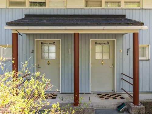 a small house with two doors and a porch at Holiday Home Rantalinna 2 by Interhome in Ruokolahti