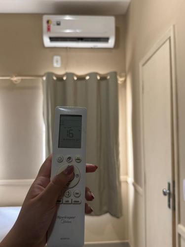 a person holding a remote control in a room at Hotel Executive Uberaba in Uberaba