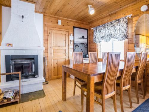 a dining room with a fireplace and a wooden table and chairs at Holiday Home Lehtotuvat e by Interhome in Kotila
