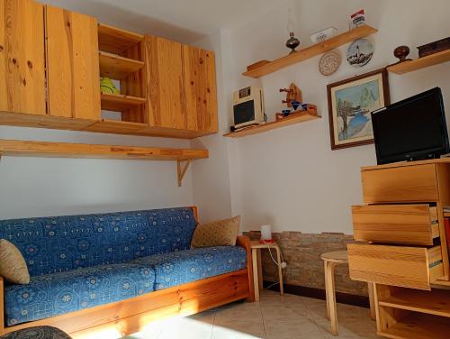a living room with a blue couch and a tv at Casa Lory in Prato Nevoso