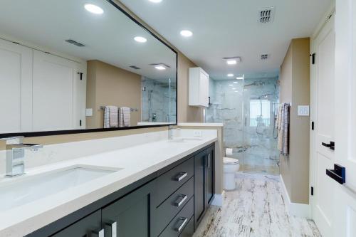 a bathroom with a sink and a toilet and a mirror at Updated 3BR w/ Gulf Views: Suntide III - Unit 801 in South Padre Island