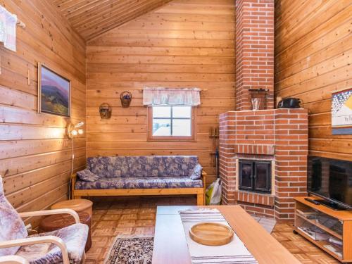 a living room with a couch and a fireplace at Holiday Home Lomapesä 10a by Interhome in Kotila