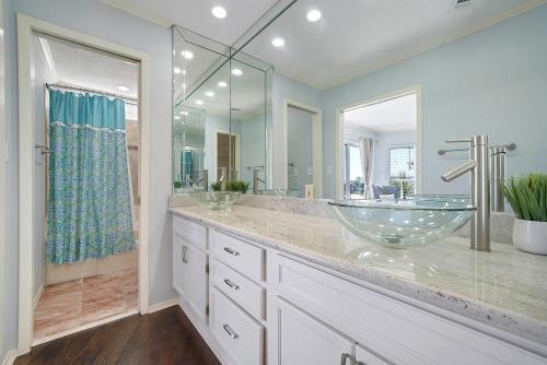 a bathroom with two sinks and a glass bowl sink at Family Tides - Beachfront Pet-Friendly Duplex in Destin