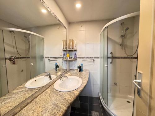 a bathroom with two sinks and a shower at Miramare Seaside Aparts in Kotor