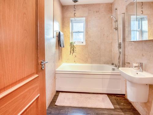 a bathroom with a bath tub and a sink at Gated Mansion Apartment- Stylish, Quiet & Secure in Bromley