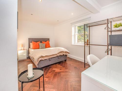 a bedroom with a bed and a table at Gated Mansion Apartment- Stylish, Quiet & Secure in Bromley