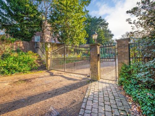 a wrought iron gate with a stone walkway at Gated Mansion Apartment- Stylish, Quiet & Secure in Bromley