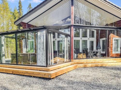an open glass conservatory on the side of a house at Holiday Home Nummentähti by Interhome in Tammela