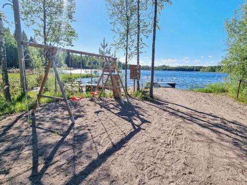 a swing set on a beach next to a lake at Holiday Home Nummentähti by Interhome in Tammela