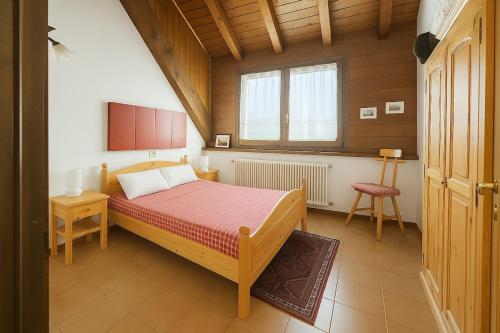 a small bedroom with a bed and a window at SkiLift Tarvisio Apartment Free Parking in Tarvisio