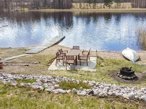 a table and chairs sitting next to a lake at Holiday Home Kivirinne by Interhome in Äijälä