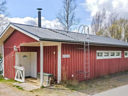 a red building with a ladder in front of it at Holiday Home Kivirinne by Interhome in Äijälä