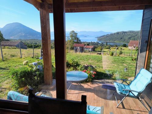 a screened in porch with chairs and a table and a view at Casa Bella Vista Futrono in Futrono