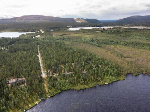 an island in the water with trees and a house at Holiday Home Jormakka by Interhome in Levi