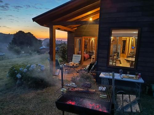 a house with a fire grill in the yard at Casa Bella Vista Futrono in Futrono