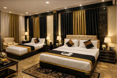 a hotel room with two beds and a chair at Hotel Aarav 94 in Indore
