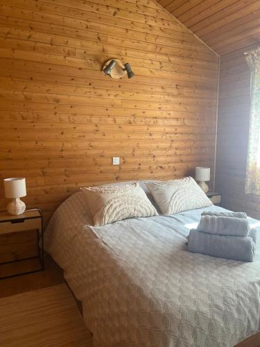a bedroom with a bed with a wooden wall at CHALET Cosy in Uxelles