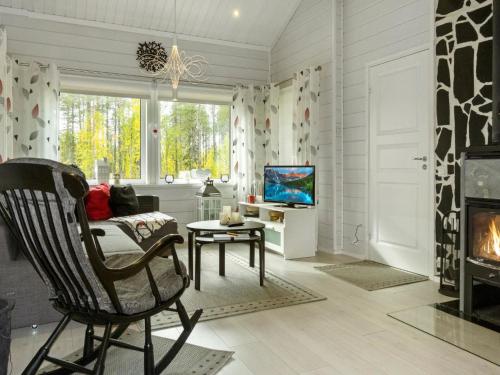 a living room with a chair and a fireplace at Holiday Home Lapinvouti by Interhome in Levi