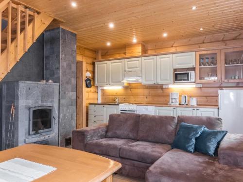 a living room with a couch and a kitchen at Holiday Home Kätkä by Interhome in Kotkasuvanto