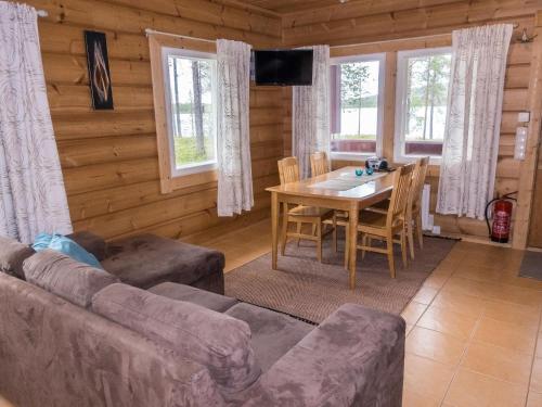 a living room with a couch and a table and chairs at Holiday Home Kätkä by Interhome in Kotkasuvanto