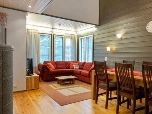 a living room with a red couch and a table at Holiday Home Pulkka 1 by Interhome in Salla