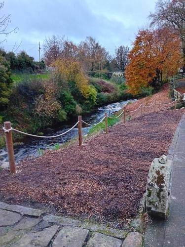 a rope fence next to a stream with a river at River View at Silver River in Cadamstown