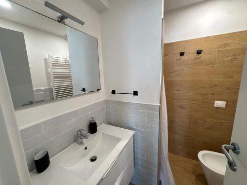 a white bathroom with a sink and a mirror at Finestre sul mare in Framura