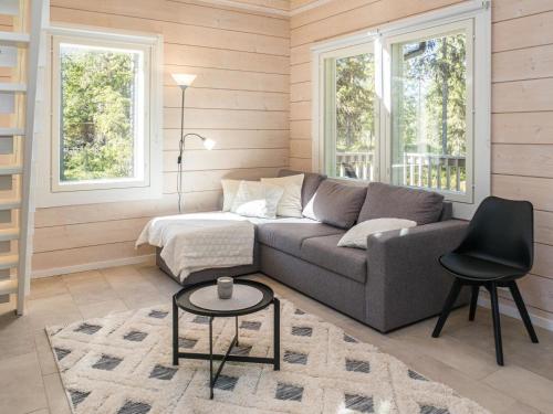 a living room with a couch and a table at Holiday Home Kitkanvee 1 by Interhome in Kuusamo
