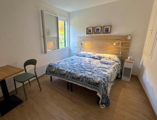 a bedroom with a bed and a table and a window at Finestre sul mare in Framura