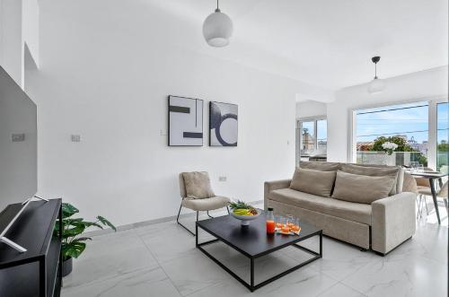 a living room with a couch and a table at STYLE°LIMASSOL in Limassol