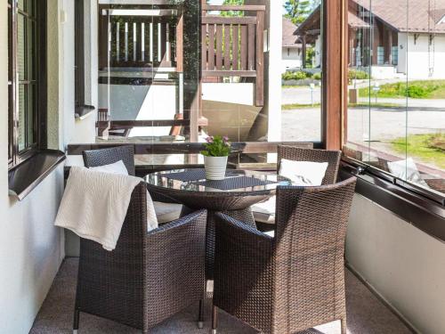 a patio with a glass table and chairs on a porch at Holiday Home Point vale 3 by Interhome in Tahkovuori