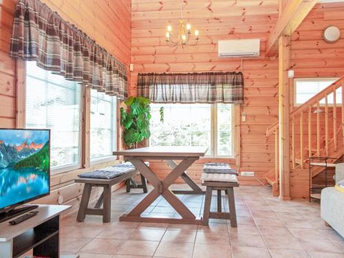 a dining room with a table and a tv at Holiday Home Tahkontupa by Interhome in Tahkovuori